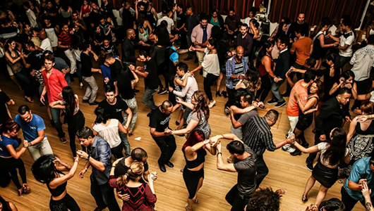 Large group of people inside a hall dancing