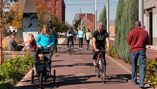 People walking and biking along the future Centennial Trail running along Civic Campus